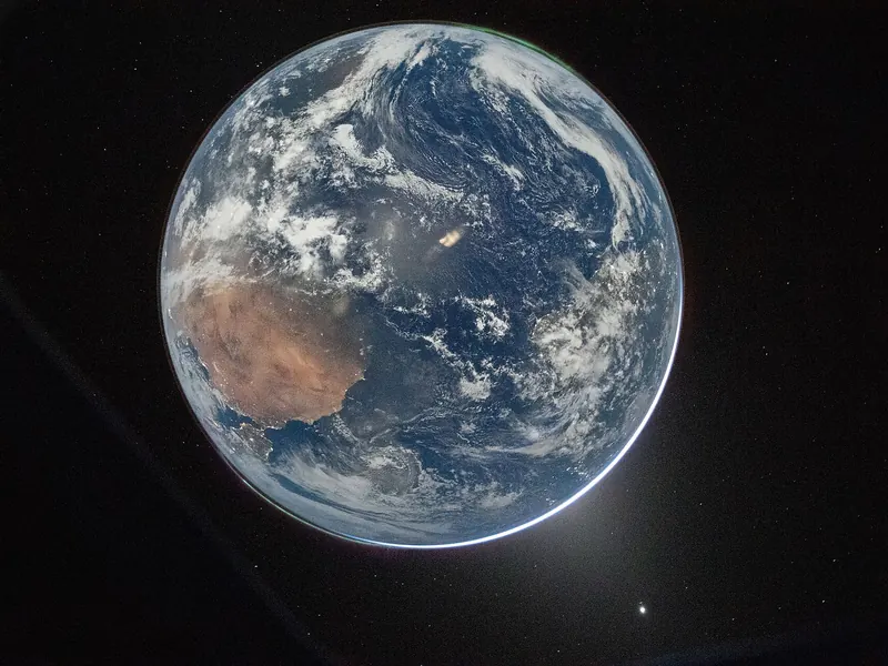 The whole Earth, a blue and white globe with a brown landmass, against black space