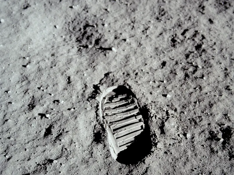 A sharp bootprint pressed into fine grey lunar dust