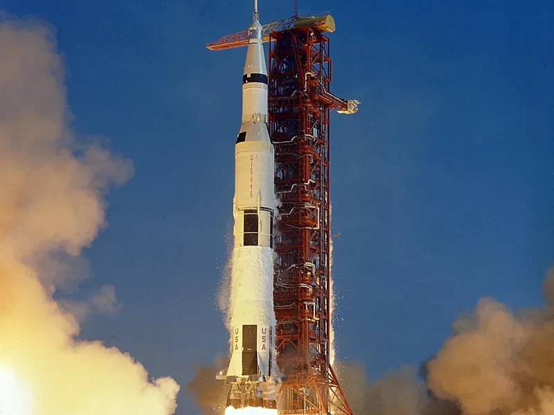 A huge white rocket lifting off on a column of flame and smoke